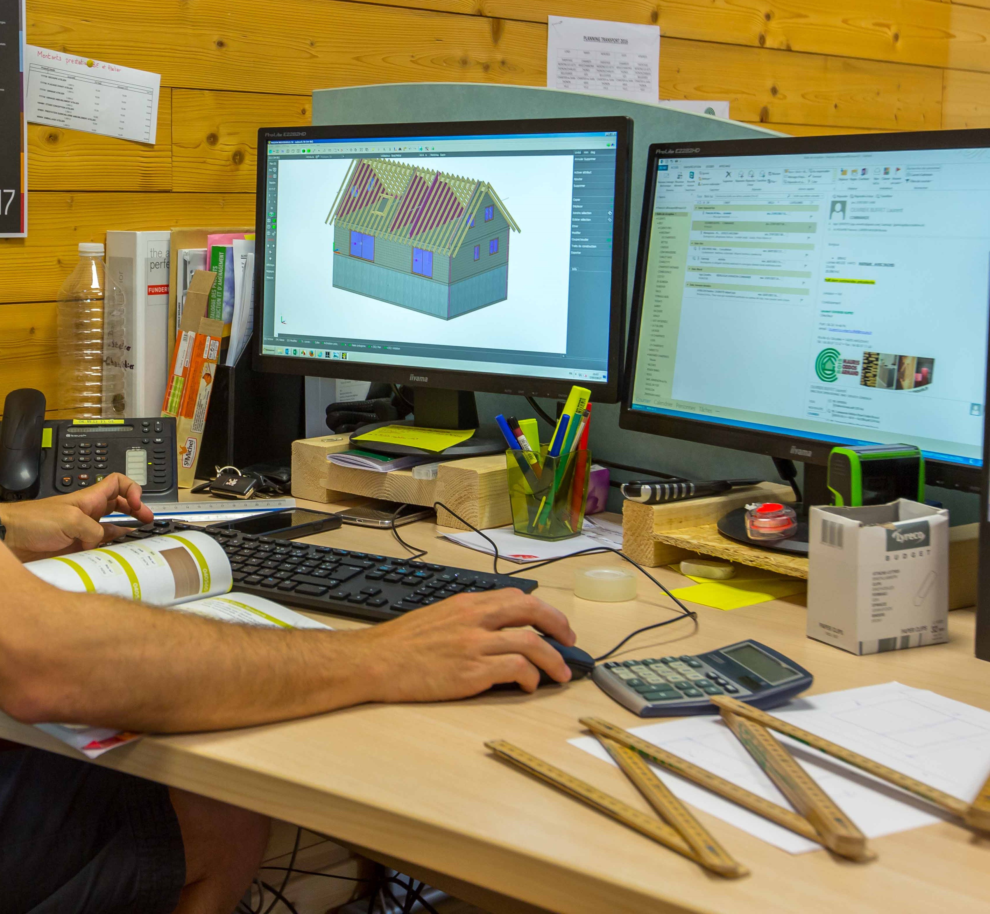 Plan de travail du bureau structure bois. Utilisation de logiciels sur l'ordinateur avec la modélisation 3D d'une maison.