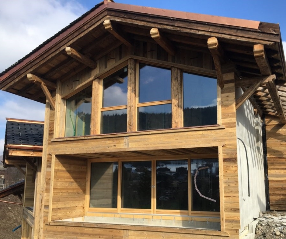 Façade de chalet avec du bardage en vieux bois procurant un effet vieux bois de grange.